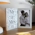 Personalized photo frame with 'Mr & Mrs' design and couple's photo on a wooden surface.
