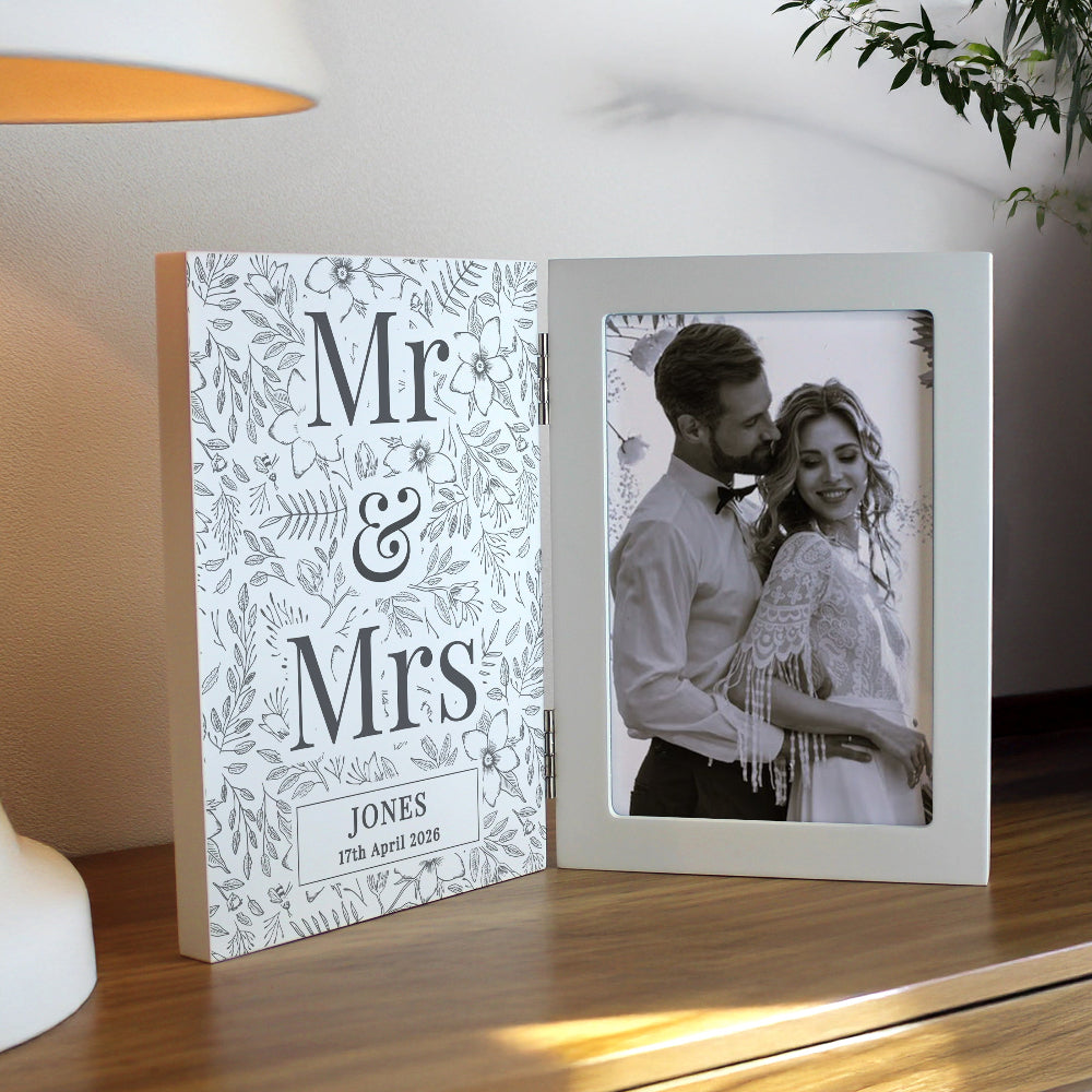 Personalized photo frame with 'Mr & Mrs' design and couple's photo on a wooden surface.