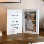 Personalized photo album with a couple's photo and text on a wooden surface.