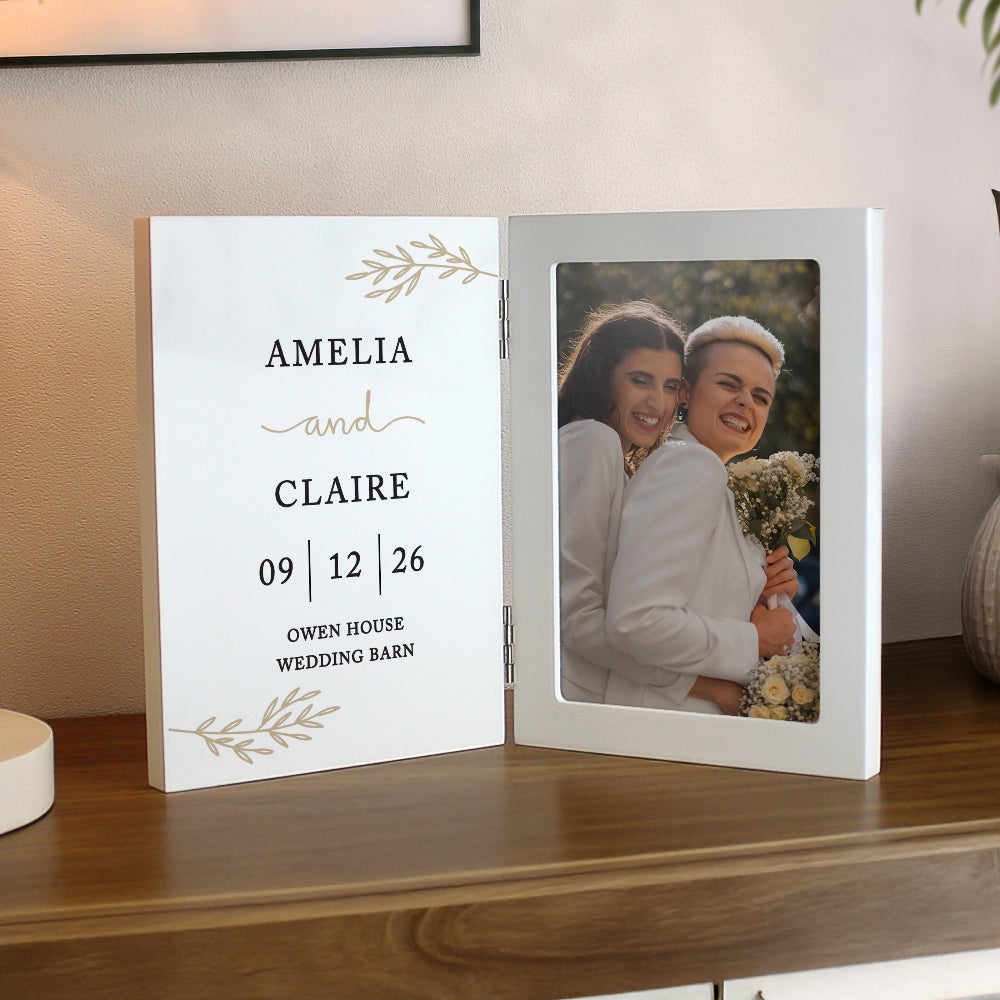 Personalized photo album with a couple's photo and text on a wooden surface.