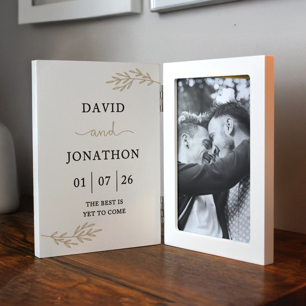 Personalized photo album with a black and white photo of two people and text on a wooden surface.