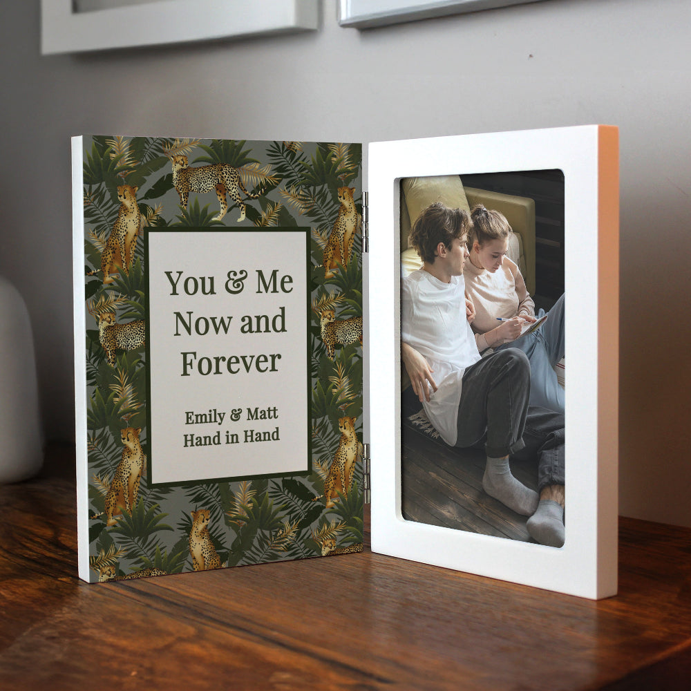 Personalized photo book with a floral cover and a photo of two people on a wooden surface.