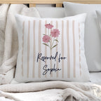 Decorative pillow with floral design and 'Reserved for Sophie' text on a striped background.