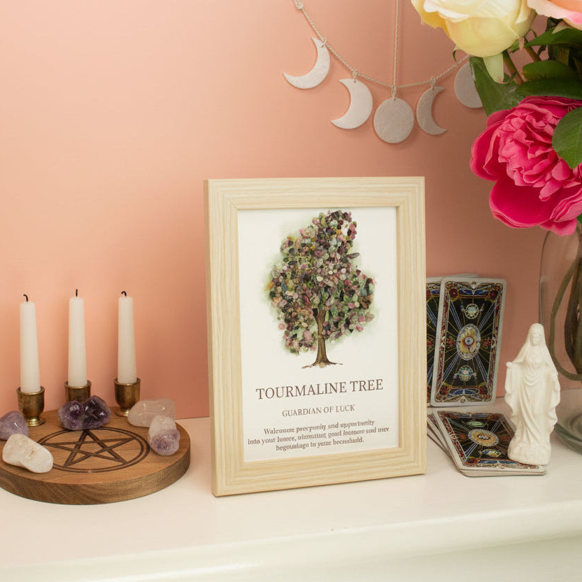 Framed artwork of a tree with crystals on a shelf against a pink wall.