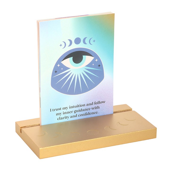 Card with an eye design and motivational text on a gold stand against a white background