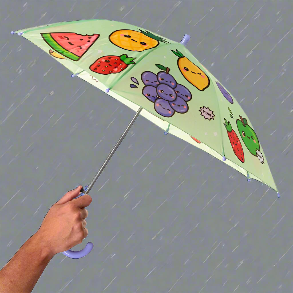 Umbrella with fruit designs held by a hand on a white background