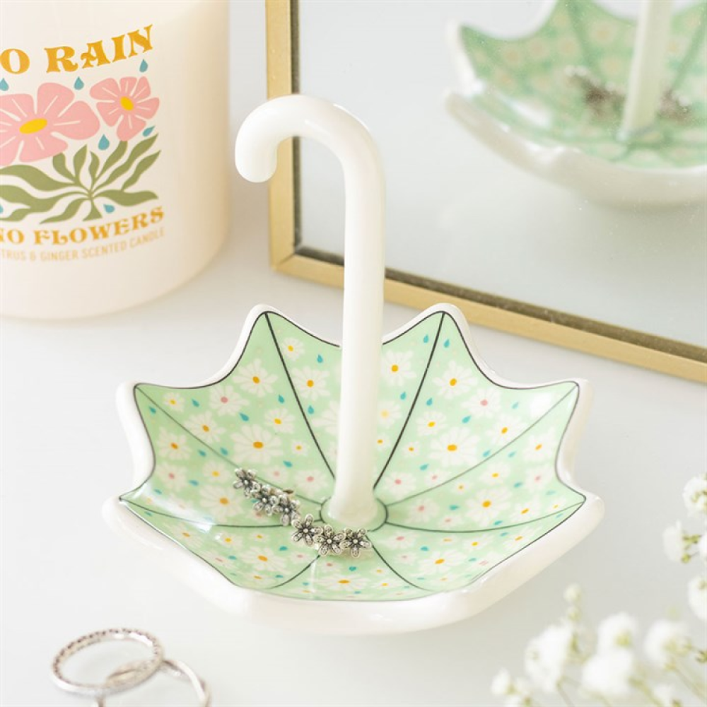 Decorative umbrella-shaped dish with a white candle inside, placed on a white surface.