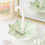 Decorative umbrella-shaped dish with a white candle inside, placed on a white surface.