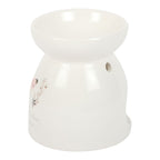 White ceramic oil burner with floral design on a white background