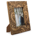 Wooden photo frame with intricate carvings on a white background
