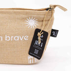 Beige pouch with white star design and 'brave' text, featuring a tag with branding on a white background.