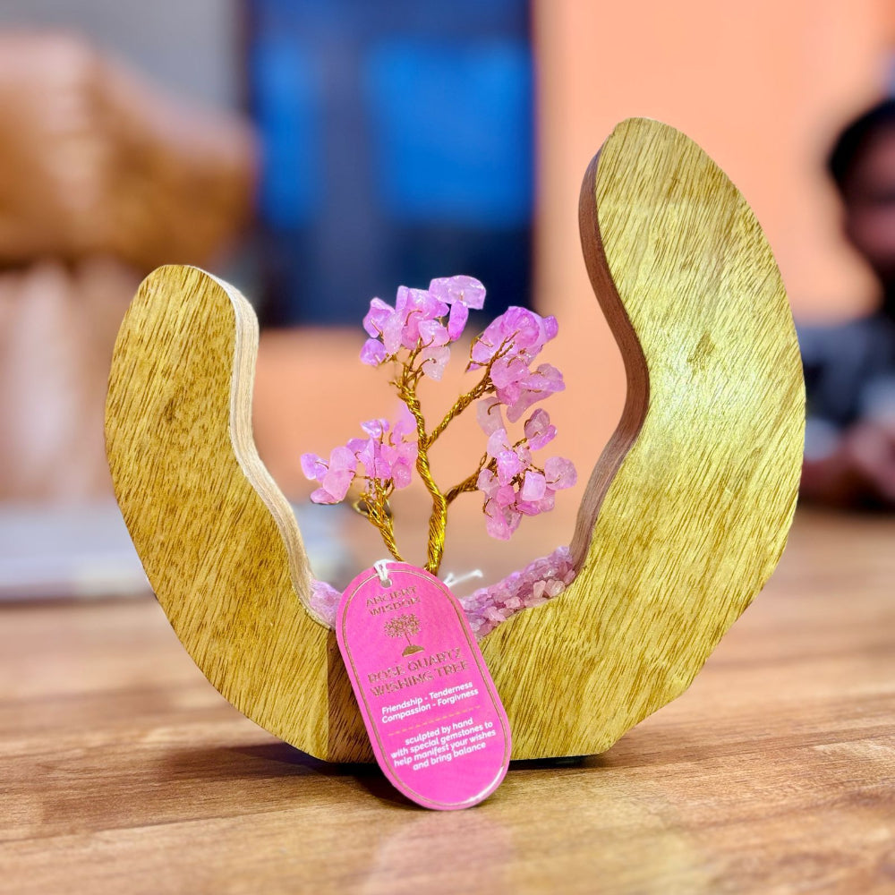 Wooden sculpture with a pink decorative tree and tag on a wooden surface