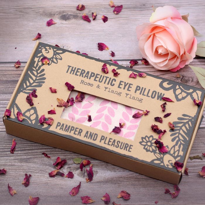 Therapeutic eye pillow packaging with decorative elements on a wooden surface