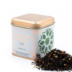 Tea canister labeled 'Mandala Leaves' with tea leaves spilling out on a white background