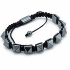 Black braided bracelet with geometric beads on a white background