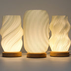 Three textured table lamps with wooden bases on a neutral background
