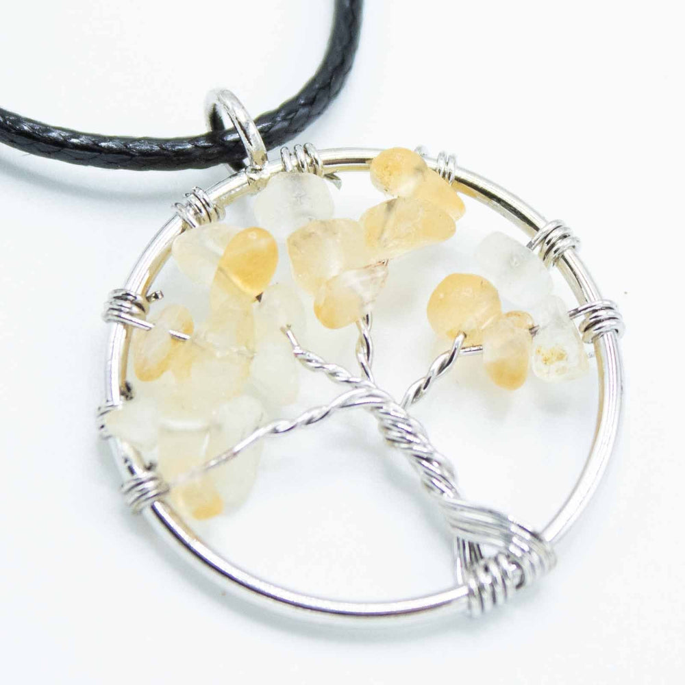 Round pendant with tree design and yellow stones on a white background