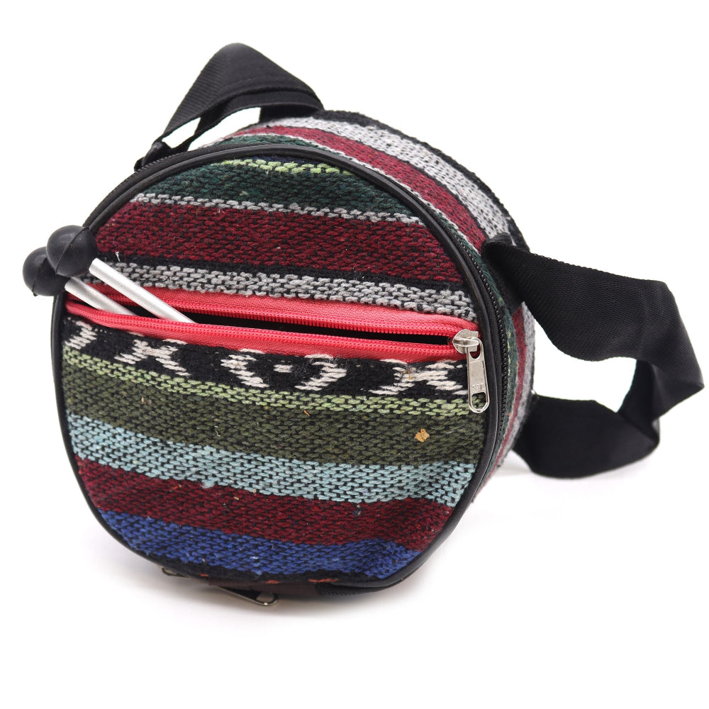 Round striped bag with a black strap on a white background