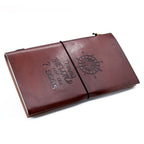 Brown leather notebook with embossed design on a white background