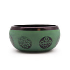 Green singing bowl with purple designs on a white background