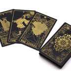 Black tarot cards with gold illustrations on a white background