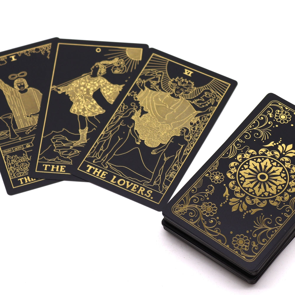 Black tarot cards with gold illustrations on a white background