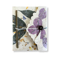 Notebook with floral design and button closure on a white background