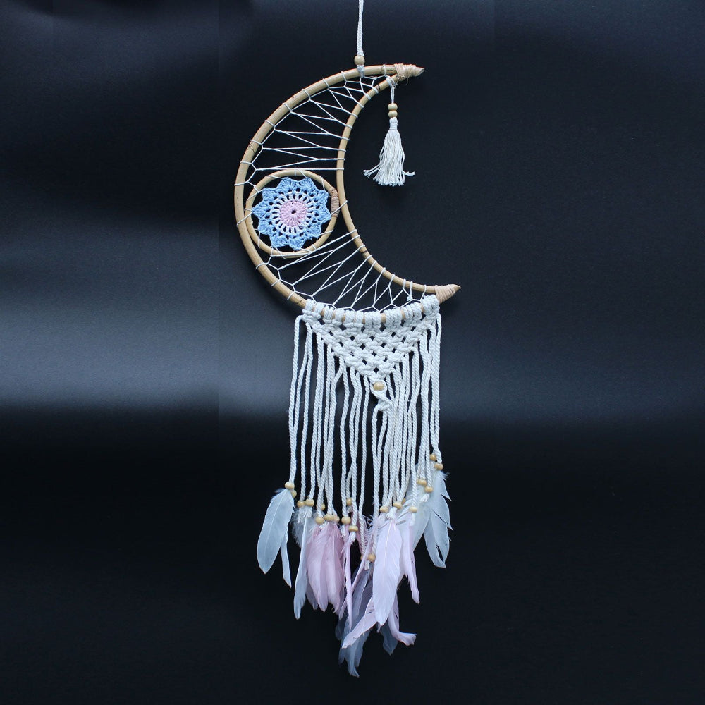 Decorative moon-shaped dreamcatcher with feathers on a black background