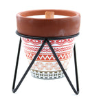 Ceramic candle pot with a patterned stand on a white background