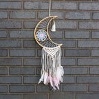 Decorative dreamcatcher with feathers hanging on a brick wall