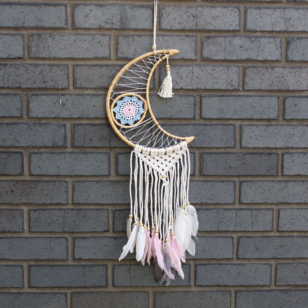 Decorative dreamcatcher with feathers hanging on a brick wall