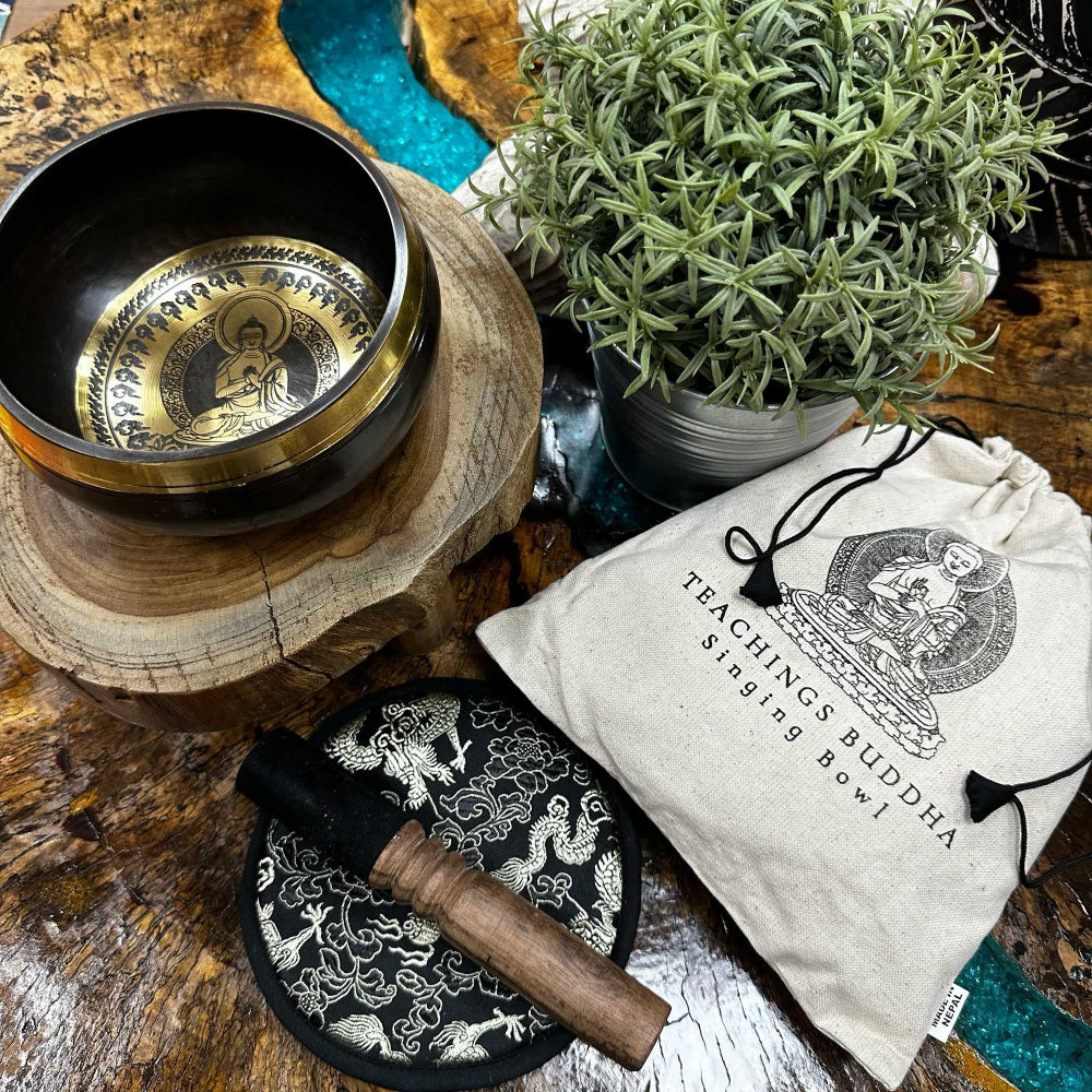 Tibetan singing bowl set with mallet and pouch on a wooden surface