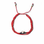 Red beaded bracelet with silver clasp on a white background