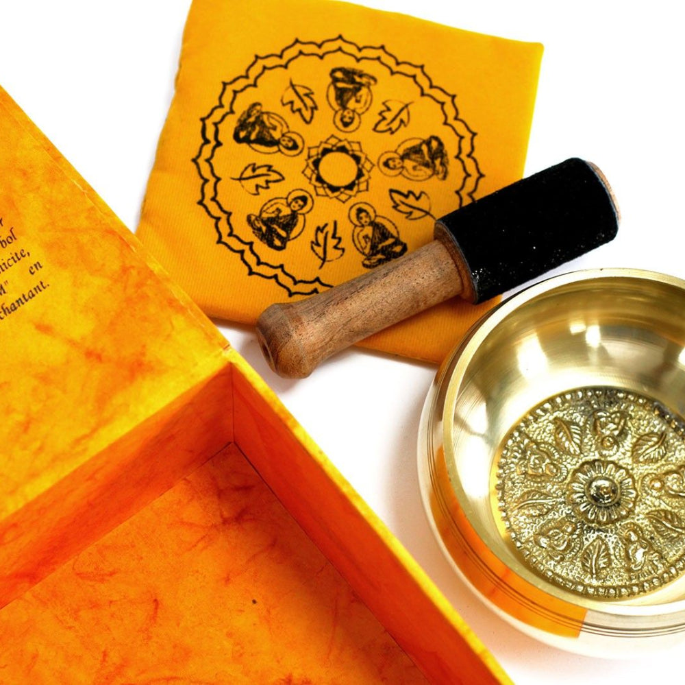 Decorative box with intricate designs, a small bowl, and a cylindrical object on a white background.