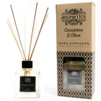 Reed diffuser with cinnamon and clove scent next to its packaging on a white background