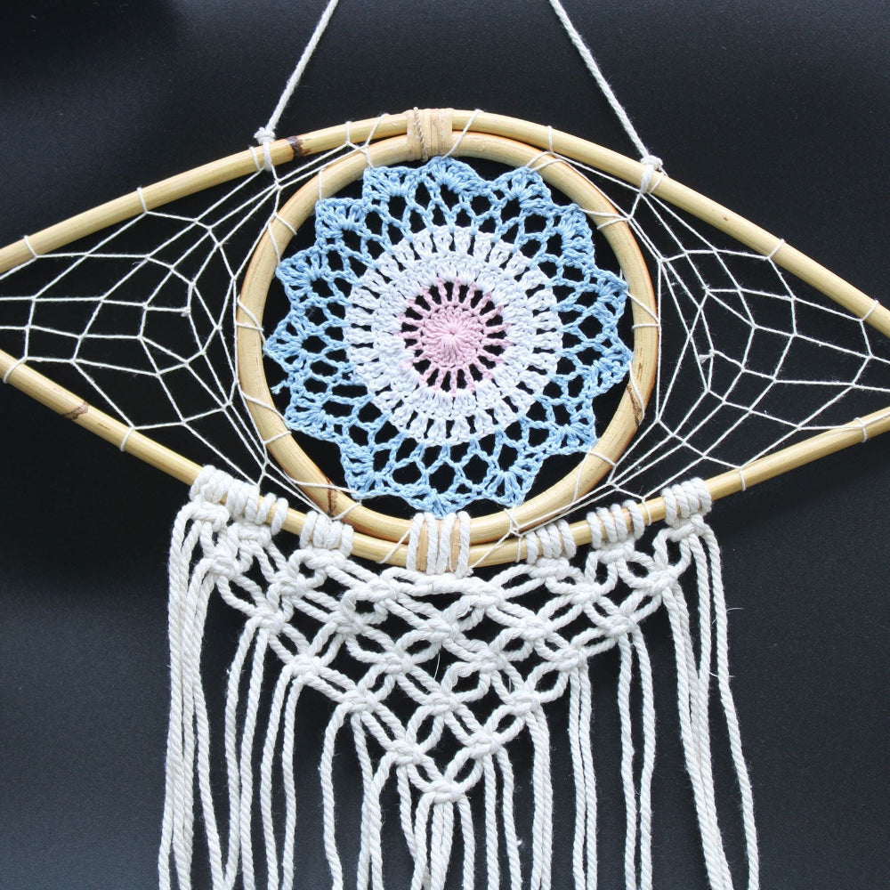 Dreamcatcher with a blue crochet center and white macrame web on a black background