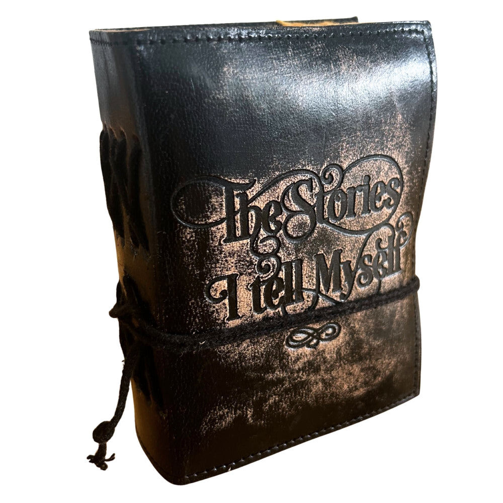 Black leather-bound book with 'The Stories I Tell Myself' embossed on it, on a white background