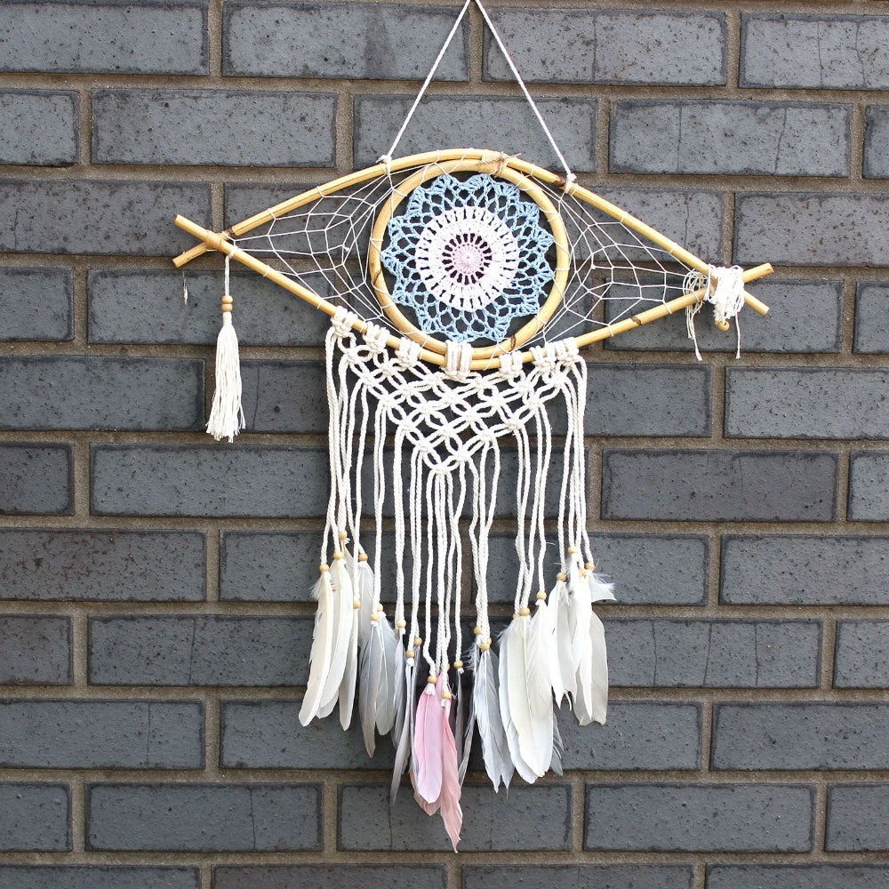 Dreamcatcher with feathers hanging on a brick wall