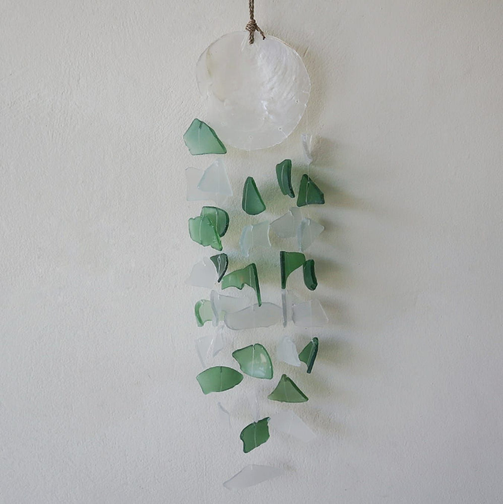 Decorative hanging with green and clear glass pieces on a white background