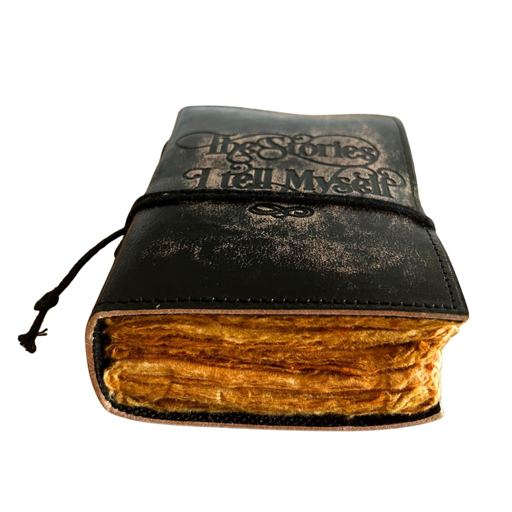Vintage-style leather-bound journal with 'The Stories I Tell Myself' text on a white background