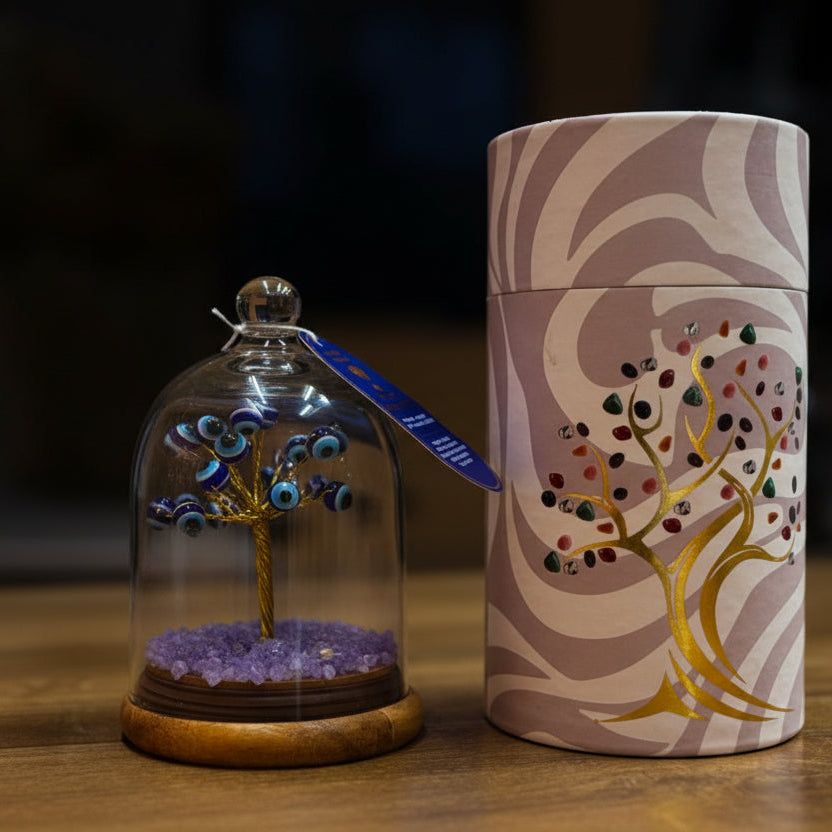 Decorative item with a tree inside a glass dome and a matching cylindrical container on a wooden surface.