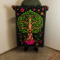 Person holding a colorful tapestry with a tree design and Buddha figure.