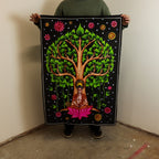 Person holding a colorful tapestry with a tree design and Buddha figure.