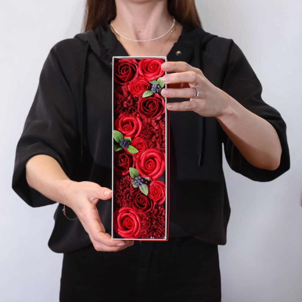 Person holding a phone case with red rose design against a white background