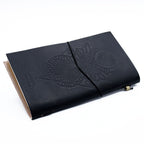Black leather notebook with embossed design on a white background
