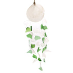 Decorative hanging ball with green and white leaf-like attachments on a white background