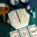 Witchcraft items including tarot cards, crystals, and a book titled 'The Spellbook' on a green surface.