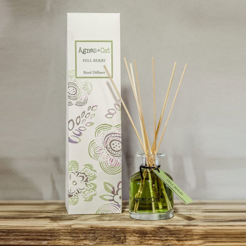 Reed diffuser with packaging on a wooden surface