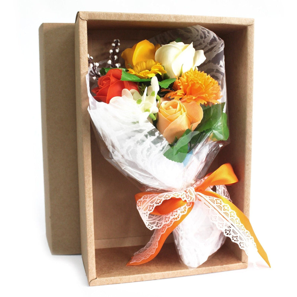Bouquet of flowers wrapped in cellophane with a decorative bow inside a cardboard box.