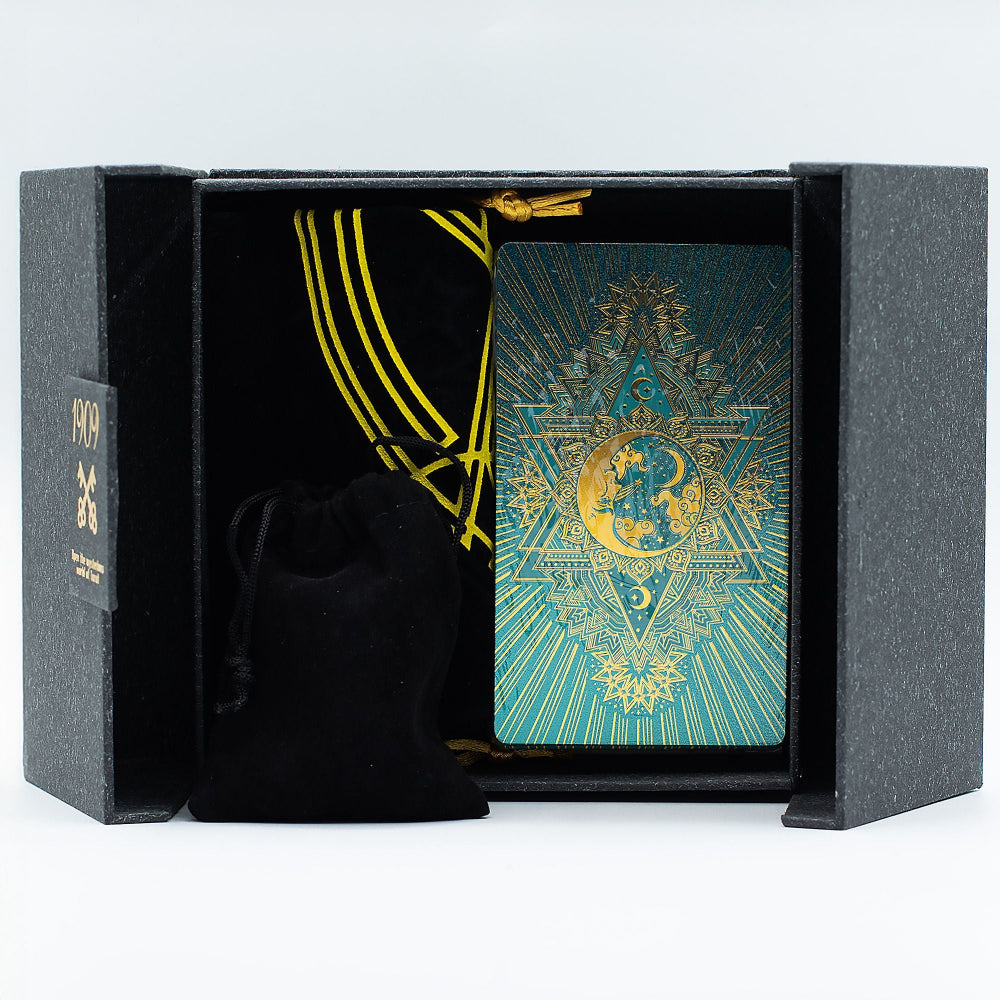 Decorative playing cards with gold and blue design in a black box on a white background